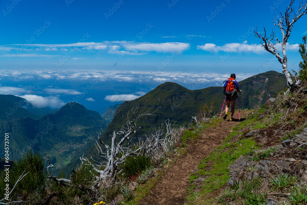 Young woman walking in the path on the mountain edge, Portugal, Madeira