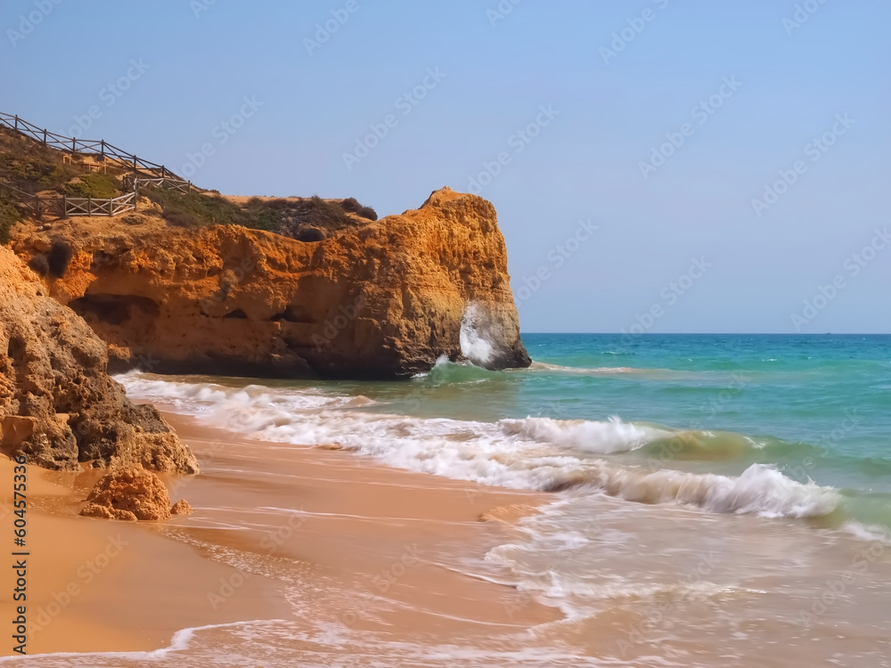 typical Algarve beach with red cliffs Praia Maria Luisa in Portugal