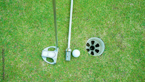 Golf ball and golf club on green in the evening golf course with sunshine in thailand