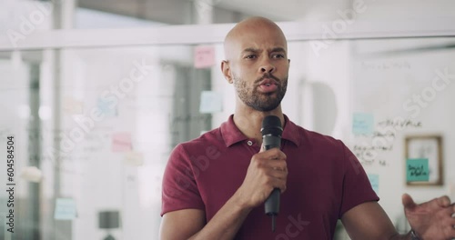 Serious businessman, speaker and presentation in seminar for coaching, motivation or speech at the office. Man employee spokesperson talking on microphone in leadership and training staff at workshop