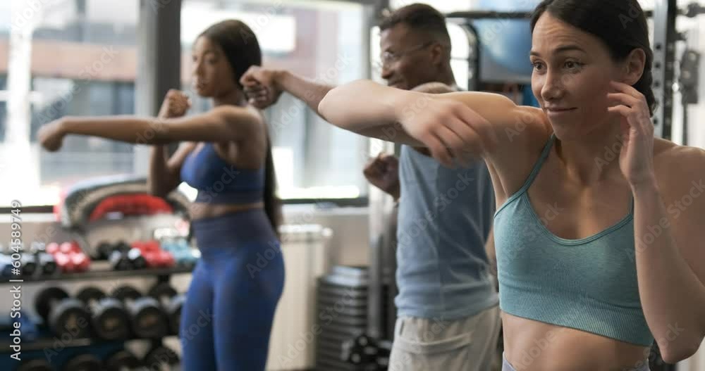 People practicing shadow boxing in a gym People practicing shadow boxing in a gym