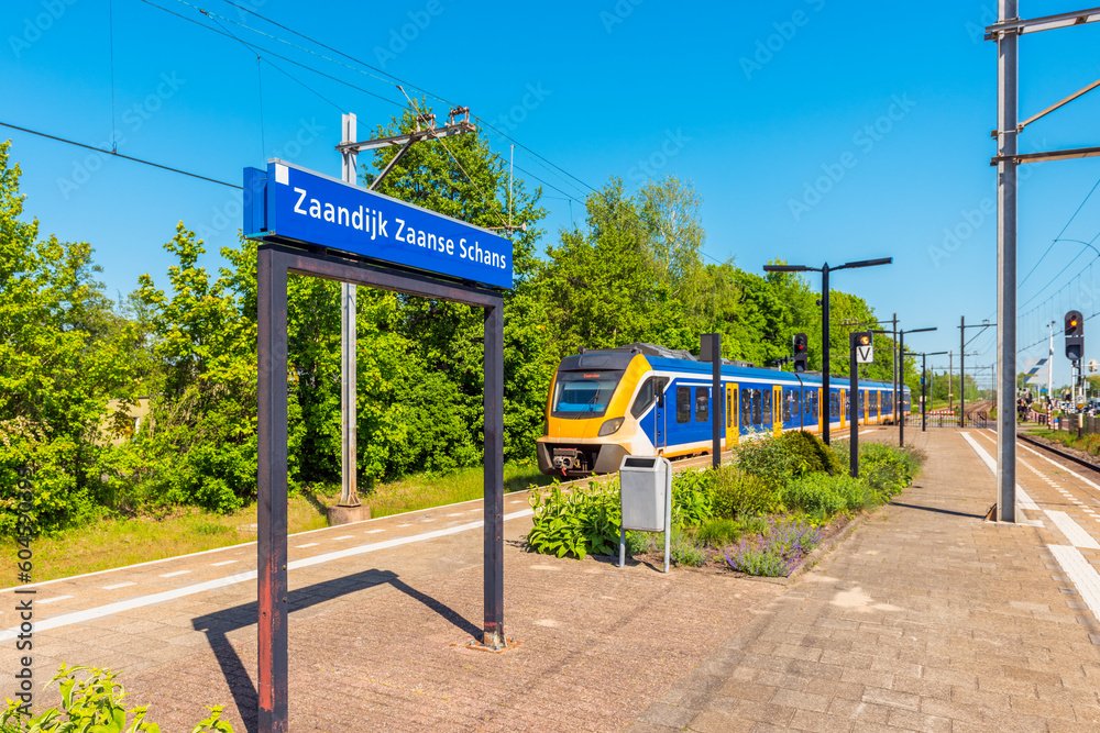 Train approaching Zaandijk Zaanse Schans Train Station in Zaandam, North Holland, The Netherlands. Zaanse Schans is a neighbourhood in Zaandam and is best known for its collection of windmills.