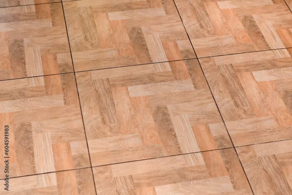 Fototapeta premium Duże płytki podłogowe z wzorem struktury drewnianego parkietu ułożonego w jodełkę