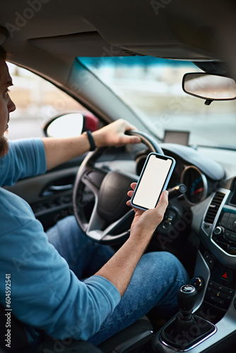 Screen blank mockup mobile phone in the hands of a man driver in a car