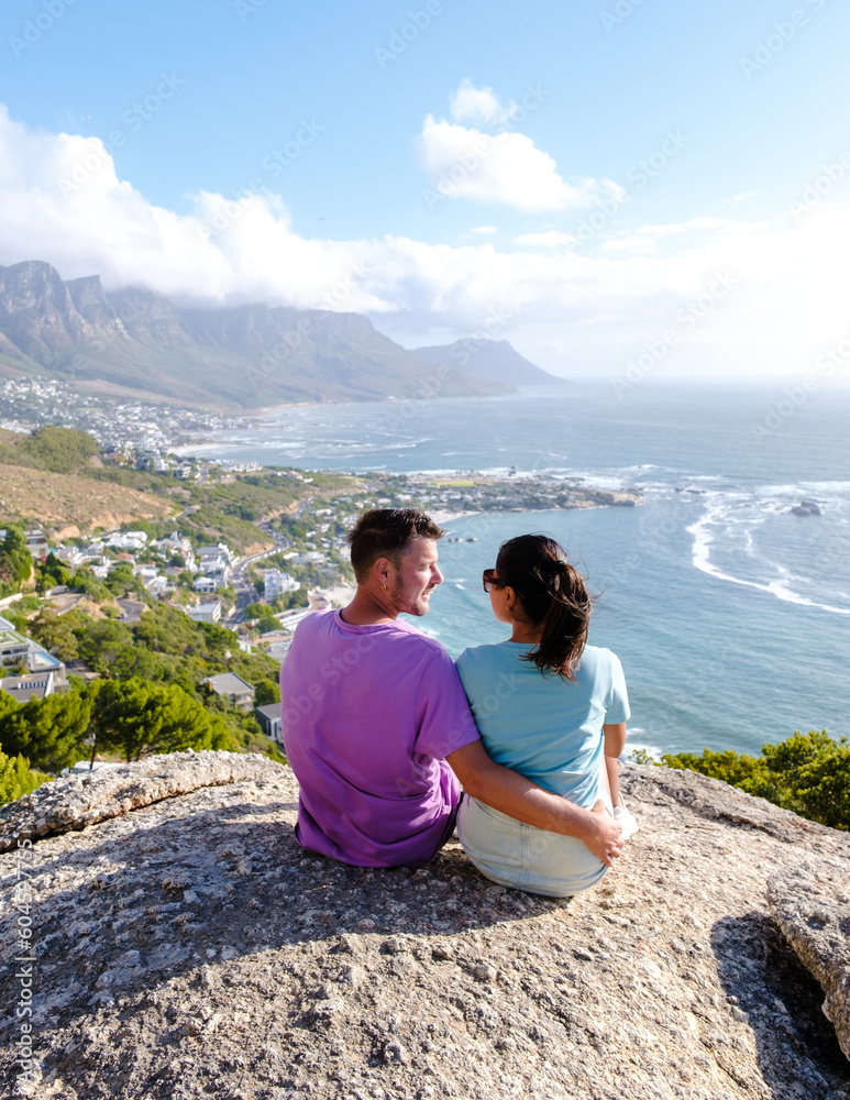 a couple of men and women at The Rock viewpoint in Cape Town over Campsbay, view over Camps Bay with fog over the ocean. fog coming in from the ocean at Camps Bay Cape Town South Africa