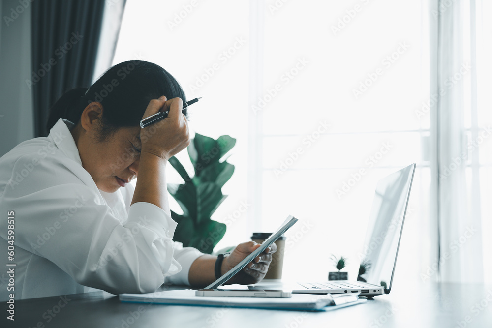 Feeling tired and stressed young women person of working age is working on wooden table in office. Professional businesswoman sleepy, depressed from overwork. Female employee feeling anxious at work. Feeling tired and stressed young women person of working age is working on wooden table in office. Professional businesswoman sleepy, depressed from overwork. Female employee feeling anxious at work.