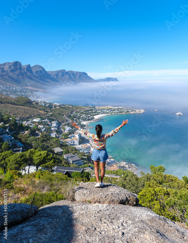 Wallpaper Mural women with hands up at The Rock viewpoint in Cape Town over Campsbay, view over Camps Bay with fog over the ocean. fog coming in from the ocean at Camps Bay Cape Town South Africa Torontodigital.ca