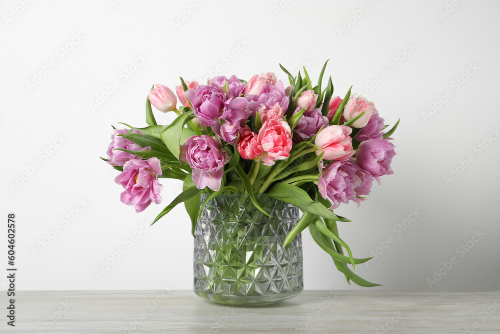 Beautiful bouquet of colorful tulip flowers on wooden table