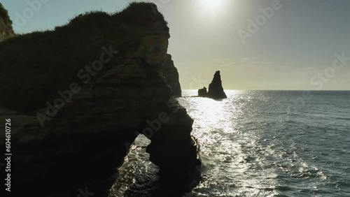 波が打ち付ける海岸と朝日に照らされる海から突き出た奇石　空撮 photo