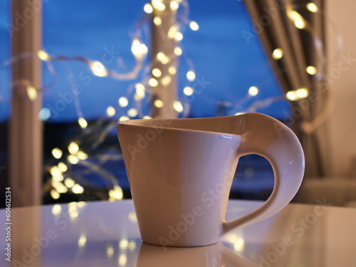 cup and coffee in front of light garland