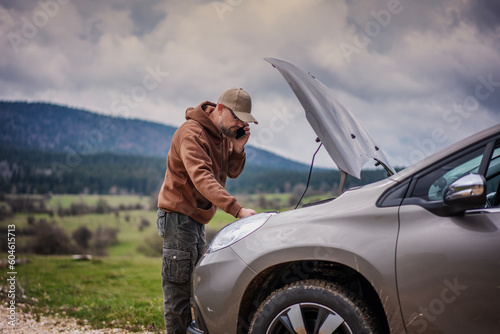 Billede på lærred Man calling roadside assistance for his breakdown car on country road standing a