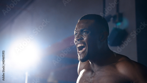 African boxers are going up to the boxing ring wearing headguards and gloves. Caucasian man punches left and right alternately. The eyes are determined to beat the opponent in the boxing ring.