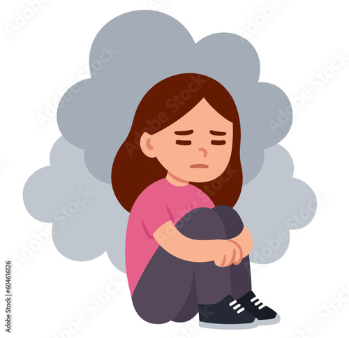 Sad girl sitting on the floor hugging knees with dark clouds around