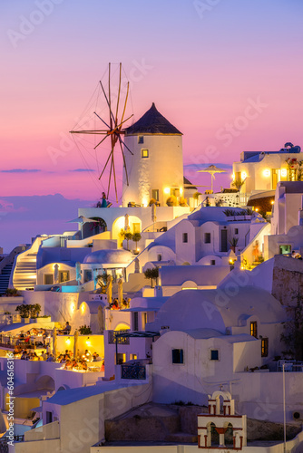Fototapeta Naklejka Na Ścianę i Meble -  Oia village, Santorini, Greece. Vacation. View of traditional houses in Santorini. Small narrow streets and rooftops of houses, churches and hotels. Landscape during sunset.