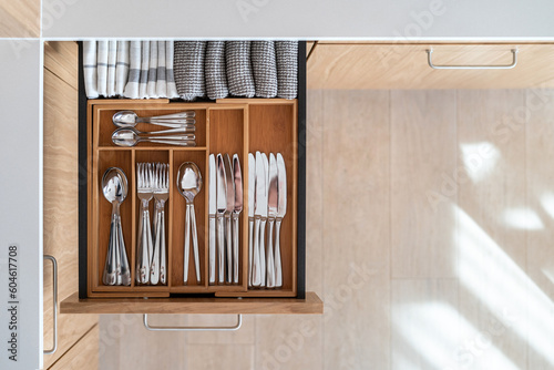 Opened kitchen drawer with wooden box for cutlery