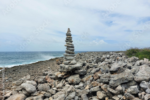 A high tower of flat stones stands on the seashore in cloudy weather