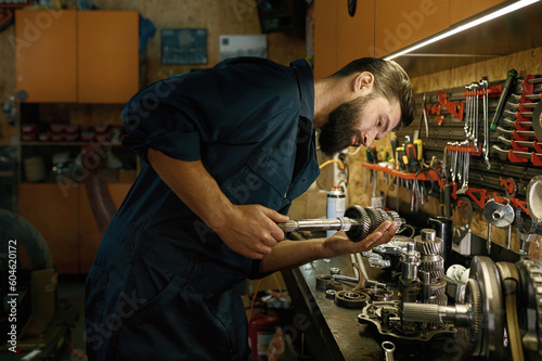 Male mechanic character working in garage repairing motorcycle