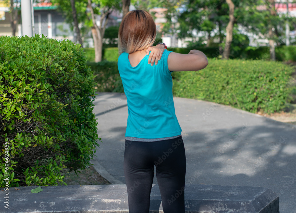 woman standing at the park and touching upper back muscles shoulder pain with injury running accident from workout ,healthy sport concept. woman standing at the park and touching upper back muscles shoulder pain with injury running accident from workout ,healthy sport concept.