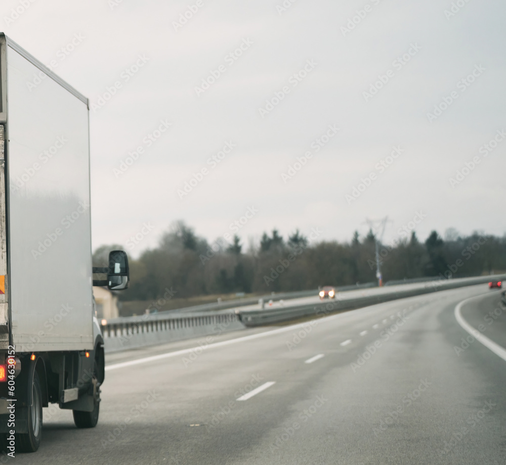 Truck with container on the highway, cargo transportation concept. A big truck moves on the highway concept of shipping company branding. Truck with container on the highway, cargo transportation concept. A big truck moves on the highway concept of shipping company branding.