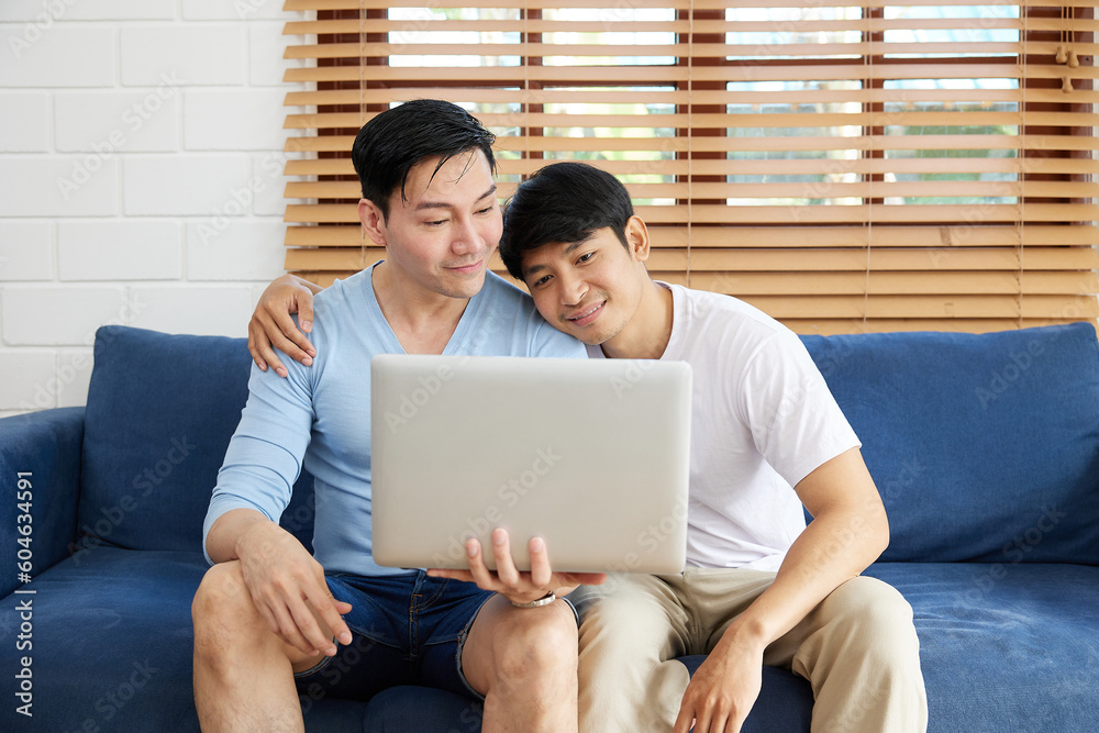 Fototapeta premium LGBT gay couple using laptop computer on sofa