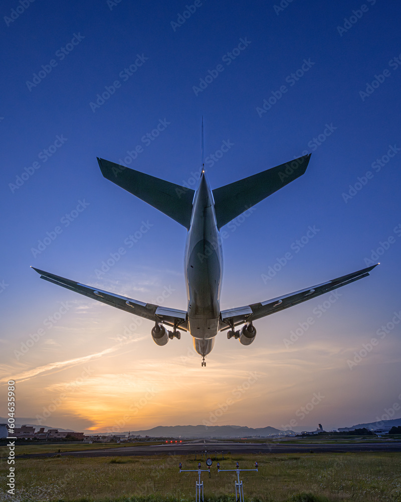 夕焼けにランディングする飛行機の写真 夕焼けにランディングする飛行機の写真