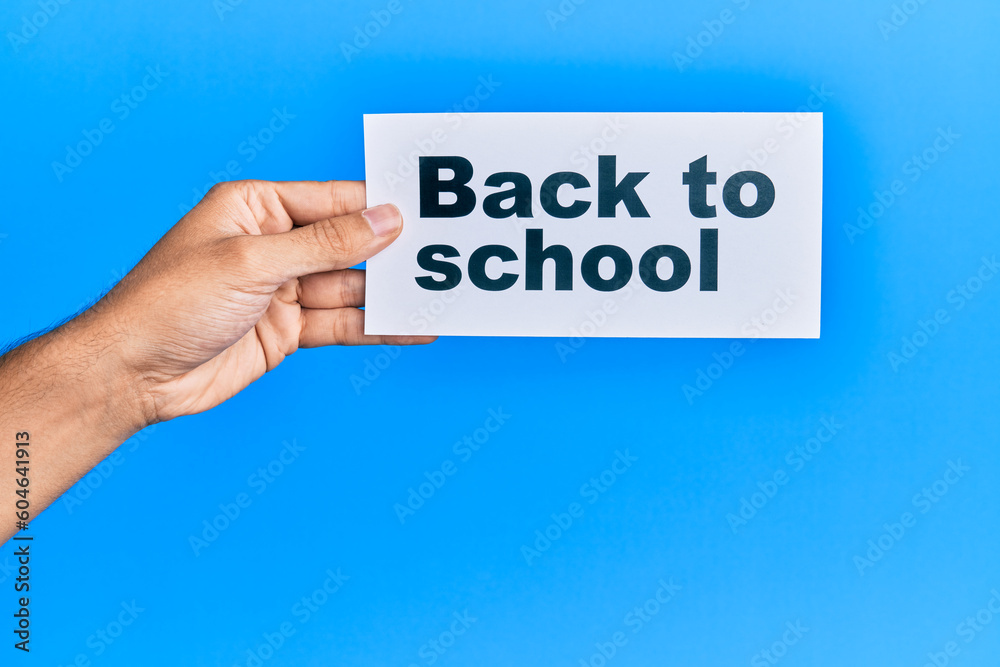 Hand of caucasian man holding paper with back to school message over isolated white background Hand of caucasian man holding paper with back to school message over isolated white background