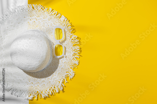 Obraz na plátne Summer flat lay white sun hat and yellow sunglasses in white plastic framed, at sunlight on bright yellow background, palm leaf shadow, copy space