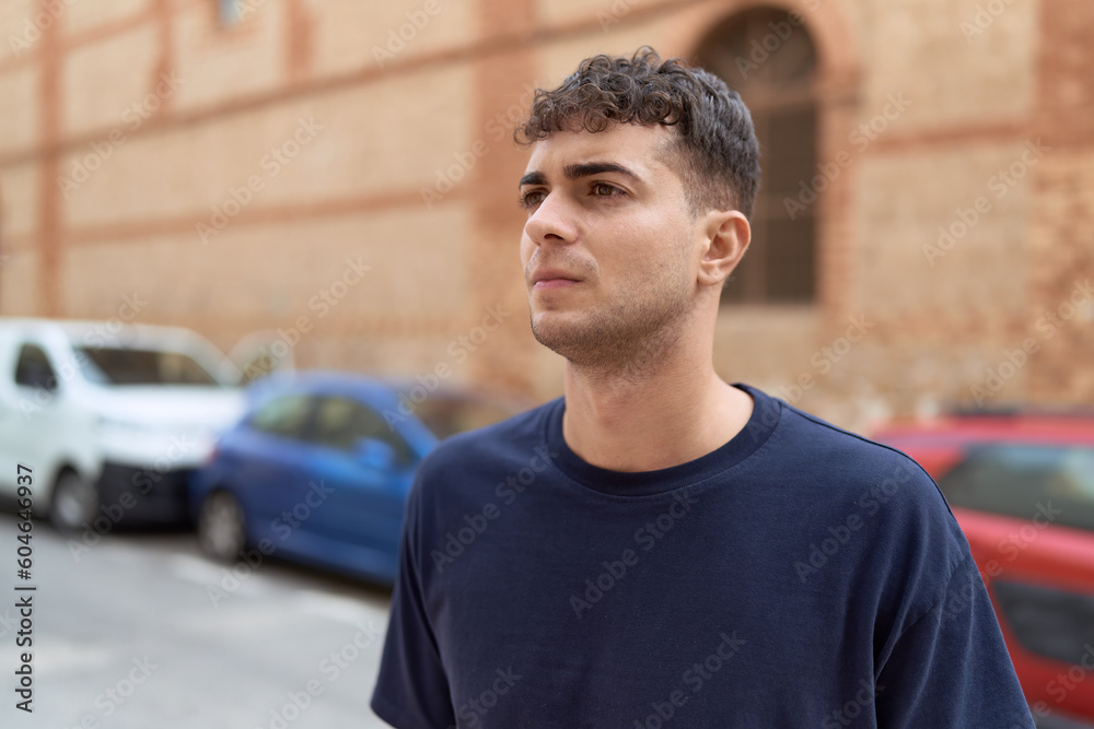 Young hispanic man looking to the side with serious expression at street Young hispanic man looking to the side with serious expression at street