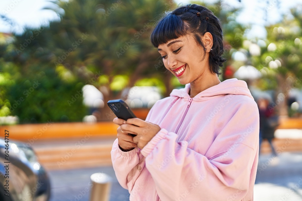 Young woman smiling confident using smartphone at park