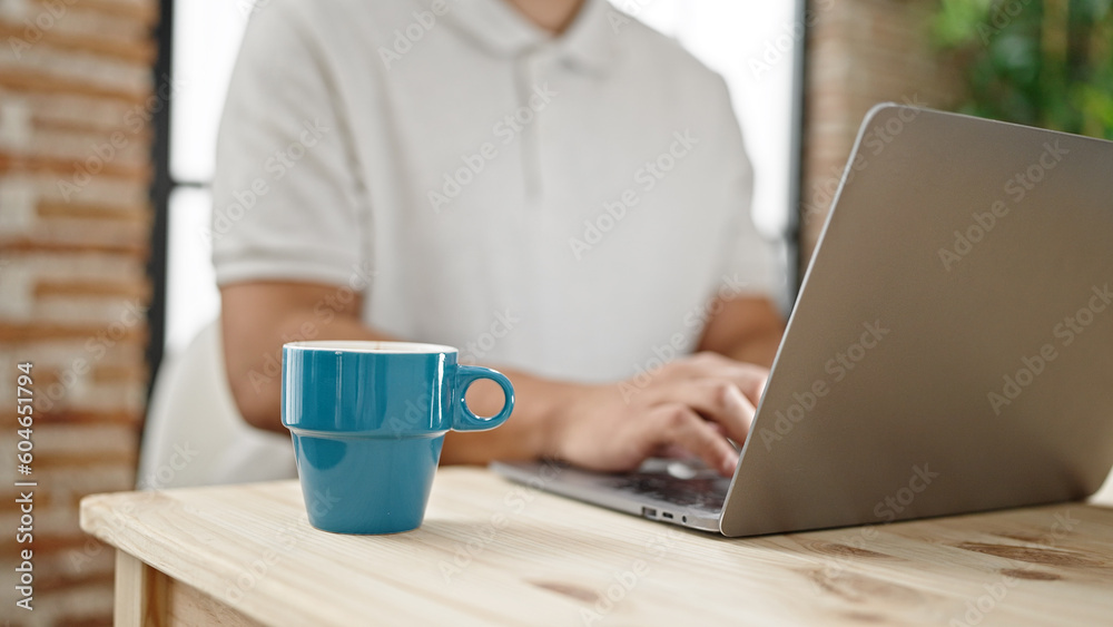 Young hispanic man using laptop sitting on table at dinning room Young hispanic man using laptop sitting on table at dinning room