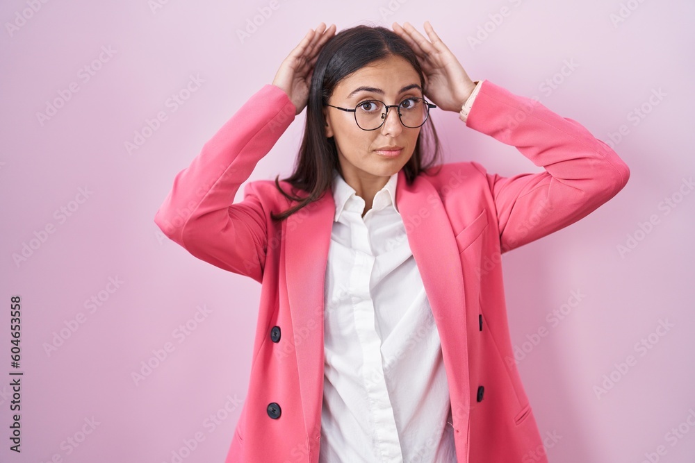 Young hispanic woman wearing business clothes and glasses doing bunny ears gesture with hands palms looking cynical and skeptical. easter rabbit concept.