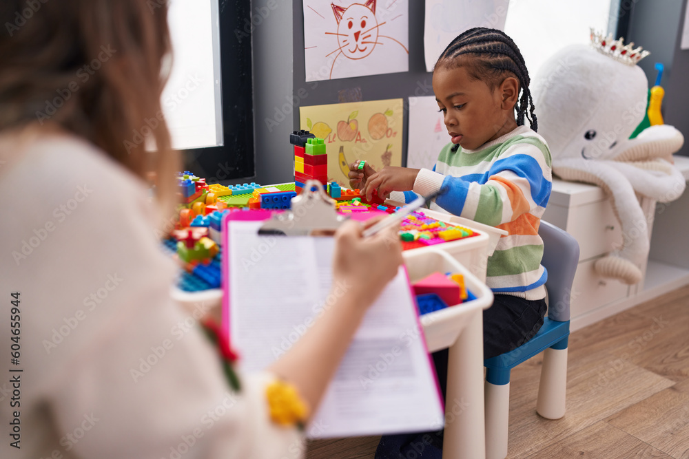 African american boy playing with construction blocks having psychotherapy at kindergarten African american boy playing with construction blocks having psychotherapy at kindergarten