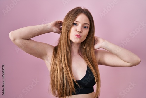 Young caucasian woman wearing lingerie over pink background looking at the camera blowing a kiss being lovely and sexy. love expression.