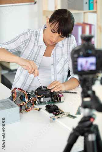 woman recording an electronics tutorial with camera on tripod
