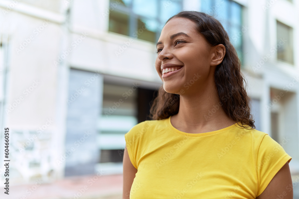 Young african american woman smiling confident looking to the side at street Young african american woman smiling confident looking to the side at street