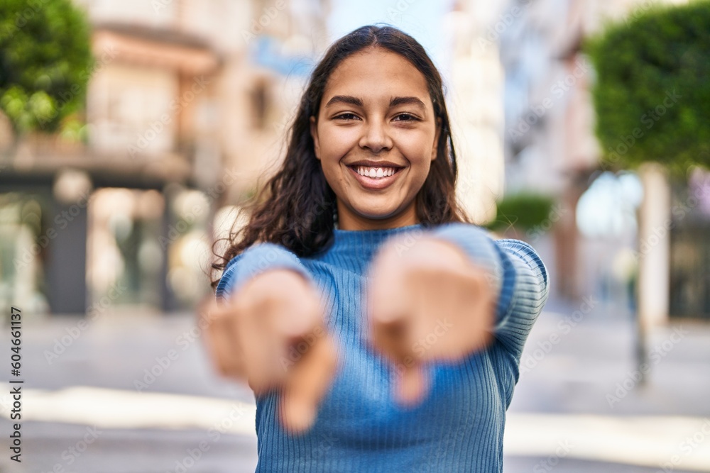 Young african american woman smiling confident pointing with fingers at street