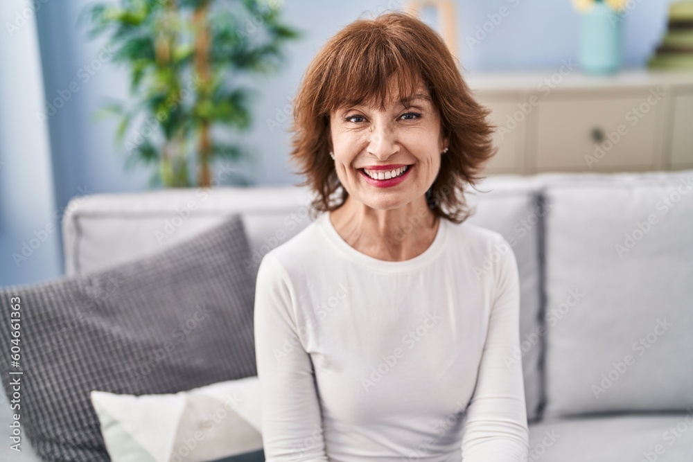 Middle age woman smiling confident sitting on sofa at home Middle age woman smiling confident sitting on sofa at home
