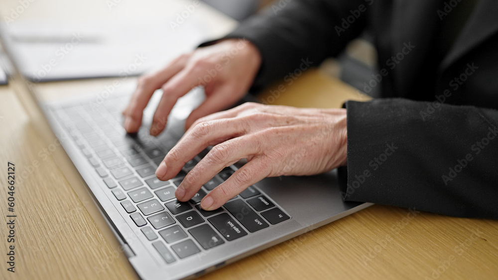Mature hispanic woman using computer typing on keyboard at office