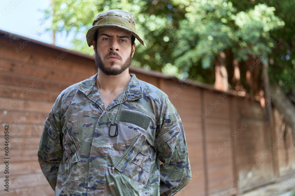 Young hispanic man wearing soldier uniform standing at park