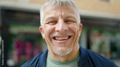 Middle age grey-haired man smiling confident standing at street