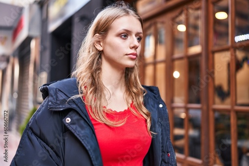 Young blonde woman looking to the side with serious expression at street © Krakenimages.com
