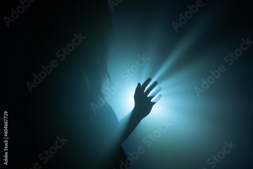 Silhouette of a hand in the rays of light