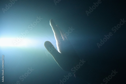 Hand being illuminated by light in the smoke