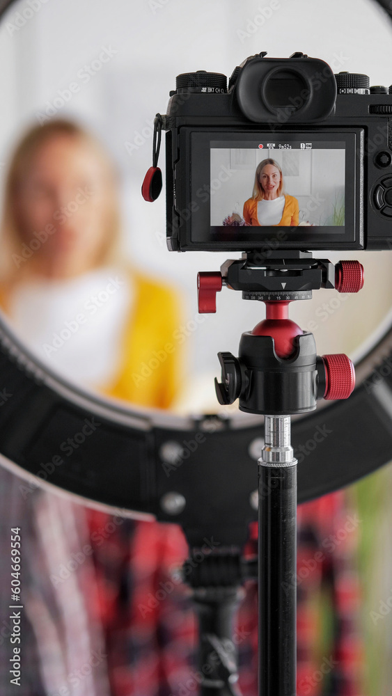 Online fashion stream. Stylist blog. Woman influencer recording video vlog on camera tripod ring light presenting trendy clothing new season. Online fashion stream. Stylist blog. Woman influencer recording video vlog on camera tripod ring light presenting trendy clothing new season.