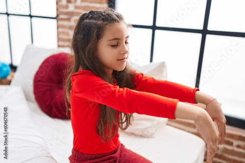 Adorable hispanic girl somnambulist sitting on bed at bedroom photo