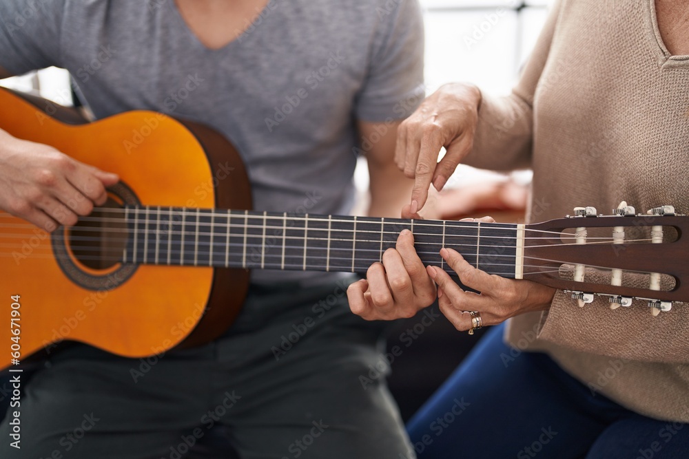 Man and woman musicians having classic guitar lesson at music studio