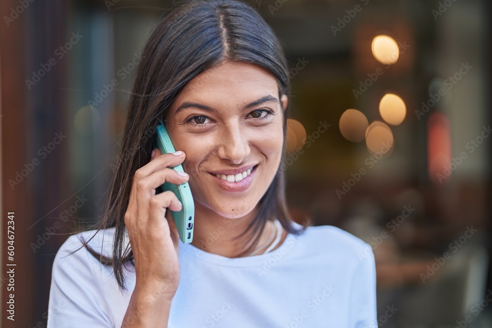 Young beautiful hispanic woman smiling confident talking on the smartphone at street Young beautiful hispanic woman smiling confident talking on the smartphone at street