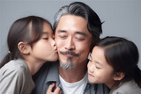 Asian mid father and children hugging and kissing on a grey background, generative ai