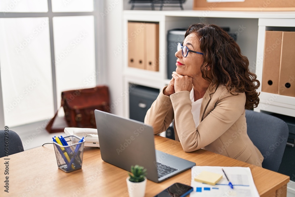 Middle age hispanic woman working with laptop at the office Middle age hispanic woman working with laptop at the office