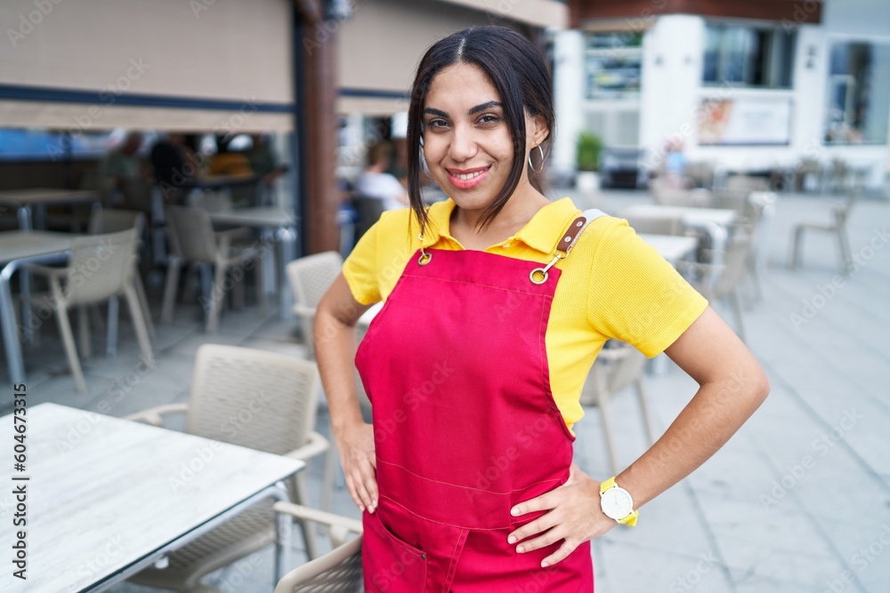 Young beautiful arab woman waitress smiling confident standing at coffee shop terrace